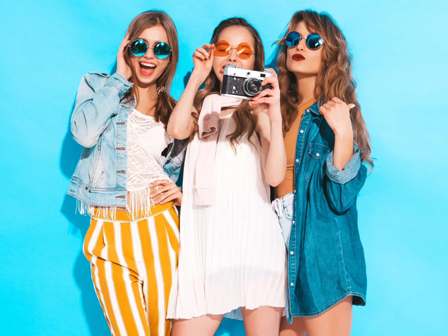 Grupo de muchachas felices viendo fotos en cámara.